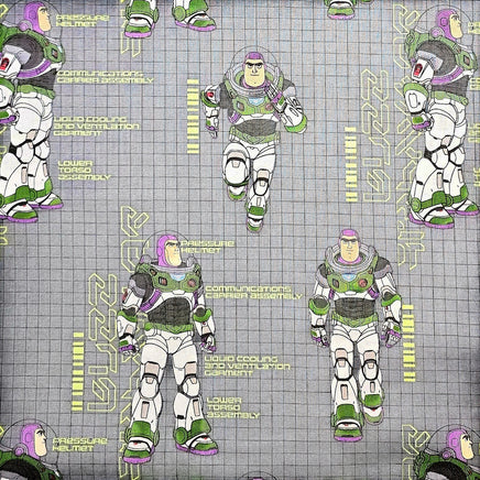 Buzz Lightyear pattern on grey fabric with tech details. 100% cotton.