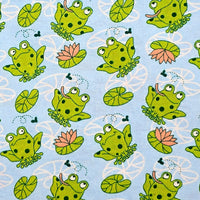 Cherry Pit Crafts microwaveable heating pad fabric with a blue background and a pattern of green frogs, lily pads, and pink lotus flowers.