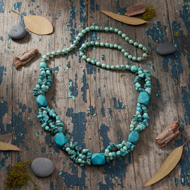 Handmade Cherry Pit Crafts turquoise beaded necklace with natural stone variations. Features layered strands of small and large turquoise beads.