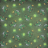 Cherry Pit Crafts green cotton fabric with a repeating pattern of green John Deere tractors and logos.