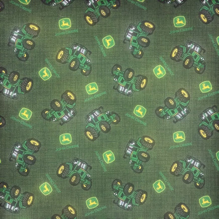 Cherry Pit Crafts green cotton fabric with a repeating pattern of green John Deere tractors and logos.