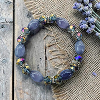 Cherry Pit Crafts lavender and iridescent faceted crystal beaded stretch bracelet with smooth oval beads.