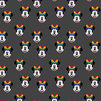 Cherry Pit Crafts microwaveable heating pad with repeating pattern of Minnie Mouse heads wearing rainbow bows on a dark grey background.