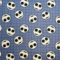 Cherry Pit Crafts Nightmare Before Christmas heating pad fabric with Jack Skellington faces on a blue grid pattern.