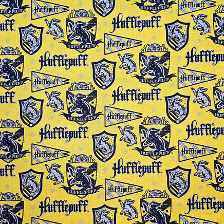 Hufflepuff-themed fabric with logos and text on a yellow background